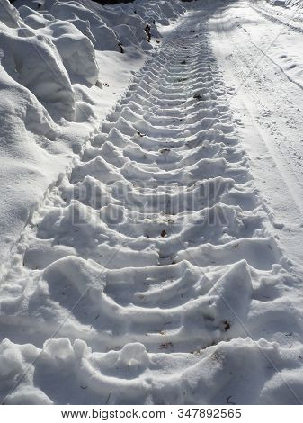 Skidmark In Snow With Sunlight