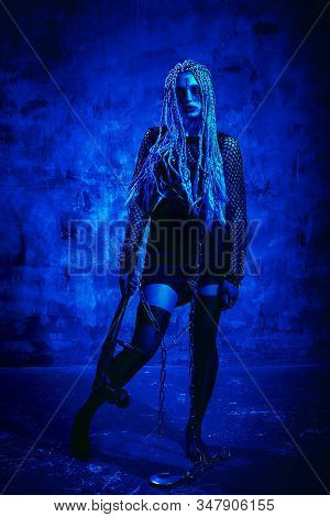 Woman With Dreadlocks And Stigmata Halloween Outfit Posing With On A Blue Background. Gorgeous Girl 