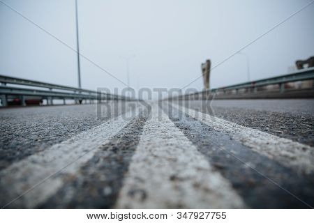 The Dividing Line On The Road Is White The View From Below On The Road Paved Going. Road Markings On