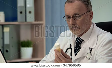 Doubtful Doctor Looking At Pills, Counterfeit Poor Quality Medicines, Placebo