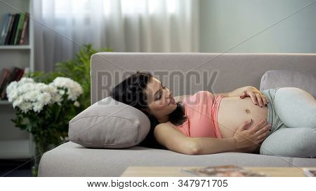 Young Future Mother Stroking Her Tummy And Communicating With Coming Newborn