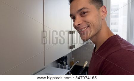 Hospitable House Owner Smiling, Meeting Guests While Cooking In Kitchen, Closeup