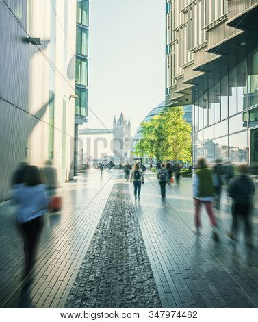 business people, modern buildings and Tower Bridge, London, UK