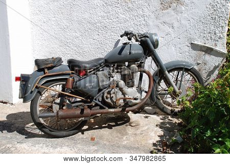 ALONISSOS, GREECE - SEPTEMBER 23, 2012: An old Royal Enfield Bullet 500 motorcycle at Rousoum on the Greek island of Alonissos. The model was first produced in the UK in 1931.
