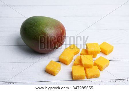 Mango And A Pile Of Mango Succades On White Wooden Background Flat Lay. Image Contains Copy Space
