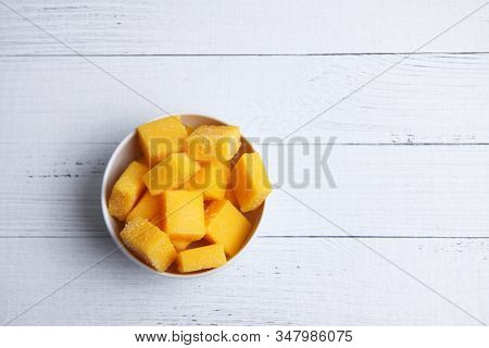 A Bowl Of Mango Succades On White Wooden Background Flat Lay. Image Contains Copy Space