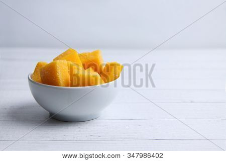 A Bowl Of Mango Succades On White Wooden Background. Image Contains Copy Space