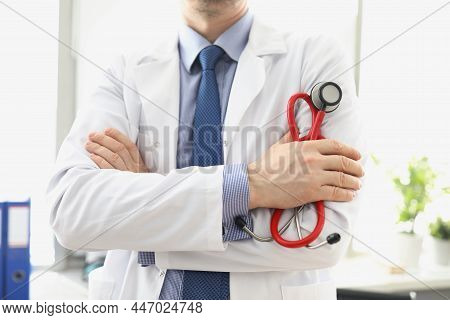 Male Doctor In A White Coat With A Stethoscope In His Hands, Close-up. Consultation With A Cardiolog