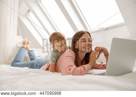 Prettyy Lady Using Laptop While Spending Time With Her Baby At Home