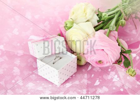 Ranunculus (Persisk Ranunkel) og forlovelsesring på pink klud