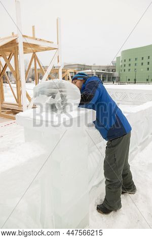 Portrait Of A Sculptor In A Blue Winter Suit With A Chisel In His Hands At Work