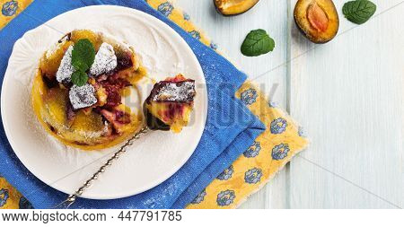 Homemade Plum Clafoutis Or Pudding On White Ceramic Plate. Rustic Homemade Plum Bakery Products Sele