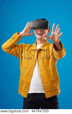 Happy Millennial Man In Vr Glasses Playing And Trying To Touch Something When Exploring Simulation O