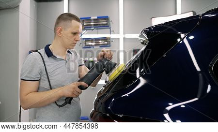A Man Is Polishing A Car With A Polishing Machine. Car Polishing. Car Detailing - Hands With Orbital
