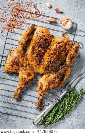 Traditional Spatchcocked Barbecue Chicken On Grill. Gray Background. Top View
