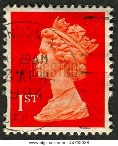 UK-CIRCA 1990:A stamp printed in UK shows image of Elizabeth II is the constitutional monarch of 16 sovereign states known as the Commonwealth realms, in red, circa 1990.