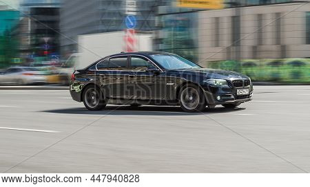 Side View Bmw 5 Series Moving On City Road. Driver In Black Sedan Rushes For Job. Moscow, Russia - A