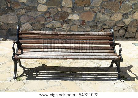 old bench on the background of a stone wall
