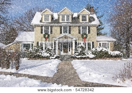 Majestic Newly Constructed Home Facade with Giant Christmas Wreaths on a Snowing Blustery Day.