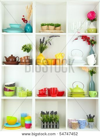 Beautiful white shelves with tableware and decor 