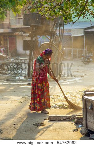 Indian Women Of Fourt Class In Brightly Colored Clothing Cleans The Street