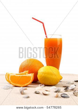Juice, orange, lemon, shells on sand.