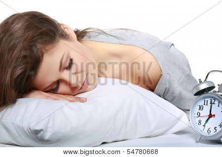 happy positive young  woman waking up and switching off the alarm clock