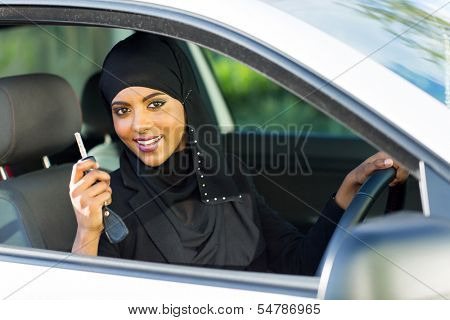 happy arabian woman holding car key inside new vehicle