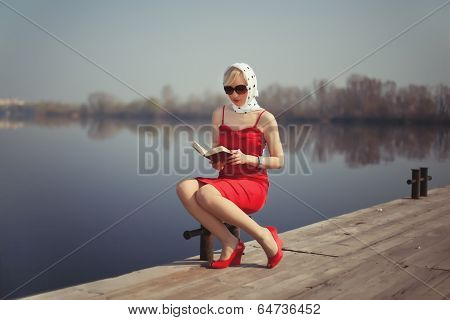 Girl In Red Dress Sitting On A Jetty