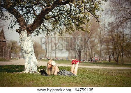 Blonde Girl Lying Under A Tree With Book
