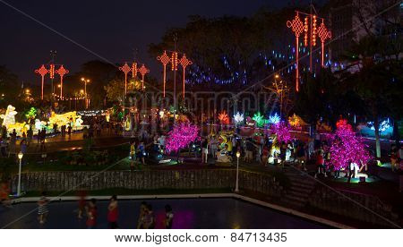 KUALA LUMPUR, MALAYSIA - FEBRUARY 23, 2015: Tourists visit the scenic Thean Hou Temple at night decorated with neon light trees and ornaments hung across the courtyard celebrating Chinese New Year.