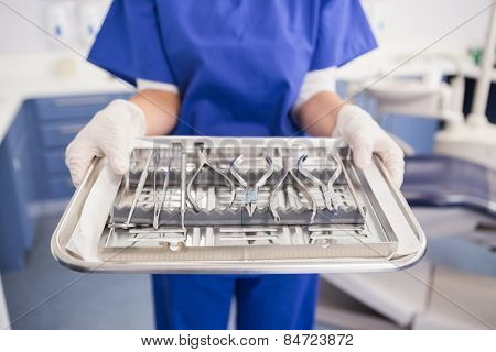 Dentist holding tray with equipment in dental clinic