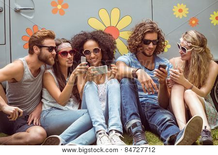 Hipster friends using their phones on a summers day