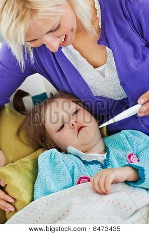 Attenta madre assume temperatura della figlia