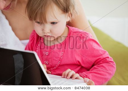 Primo piano di una ragazza affascinato utilizzando un computer portatile con la madre