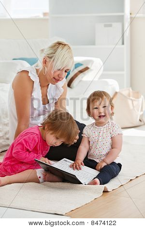 Ridere bambina utilizzando un computer portatile con la sua famiglia