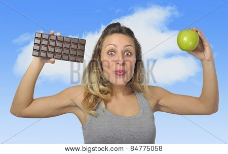 Attractive Woman Holding Apple And Chocolate Bar In Healthy Fruit Versus Sweet Junk Food Temptation