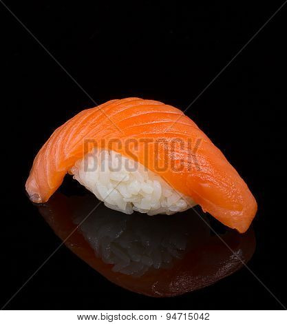 Salmon sushi nigiri clodeup over black background with reflection