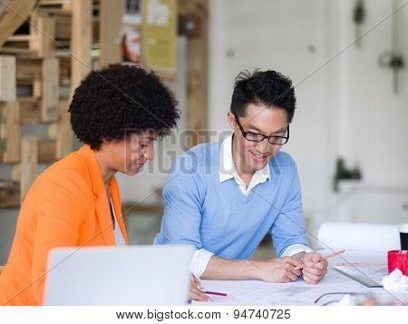 Two desingers working on a project together in office