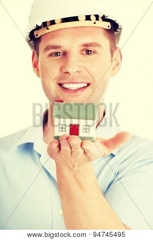 A forewoman holding a model house in hand