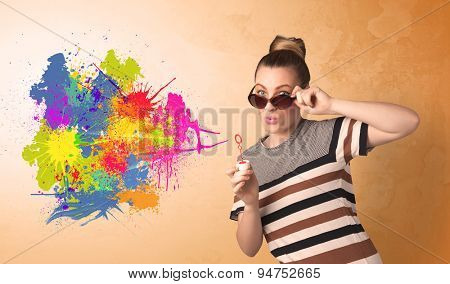 Cute girl blowing bubble spalsh graffiti into wall