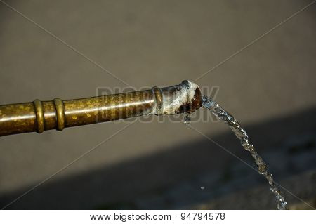 Close-up Of Water Running From Outdoor Copper Well With Limescale