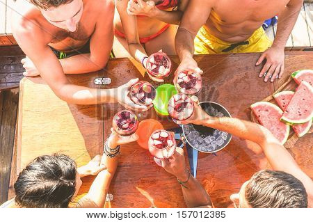 Happy friends having fun outdoors in boat party - Young people enjoying summer vacation together toasting wine with fruit - Youth and friendship concept