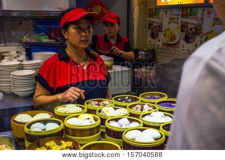 CHENGDU CHINA - JUNE 20: Woman selling traditional and delicious variety of Chinese steamed buns in restaurant in June 2016