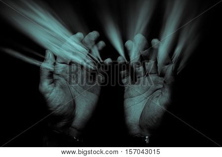 An abstract image of old hands and sand falling upwards.