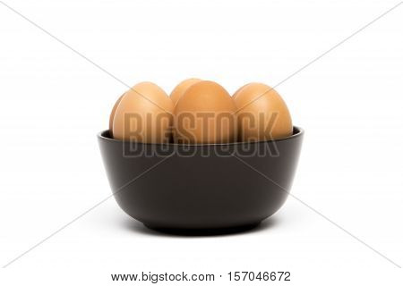 A brown ceramic bowl with brown farm eggs