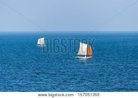Boats sailing on calm blue sea on sunny day