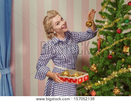 portrait of nice young woman hanging around christmas tree on x-mas  eve
