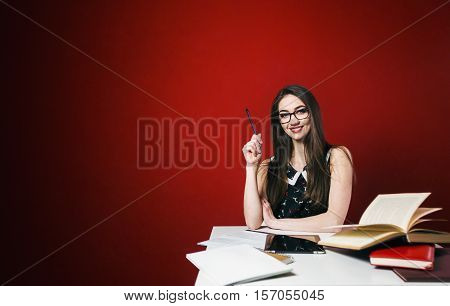 Young attractive brunette happy girl in glasses studying with book