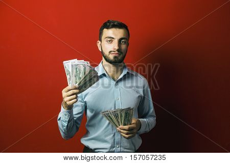 Attractive man with dollars banknotes on red background, jackpot concept